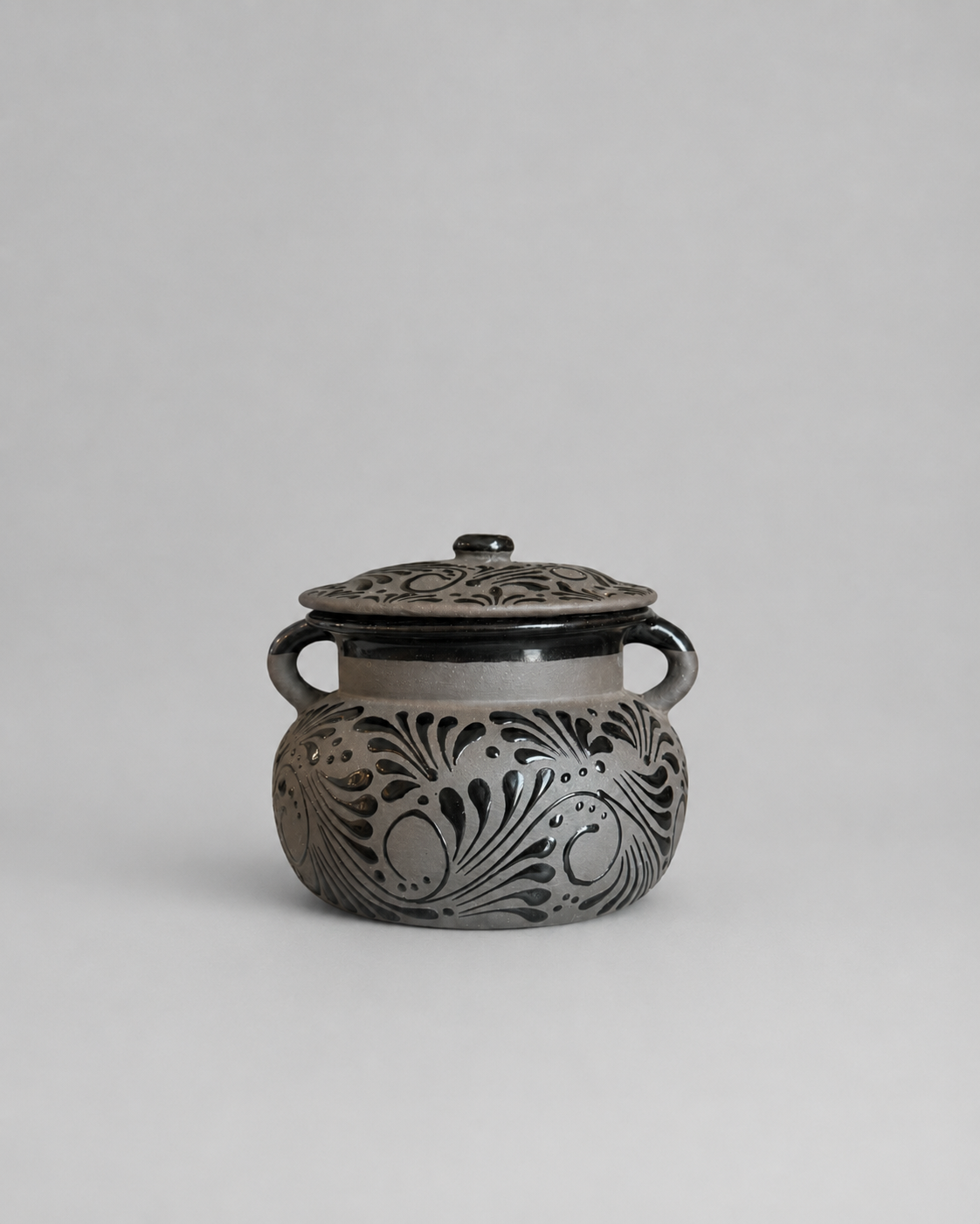 Decorative ceramic jar with floral patterns on a gray background