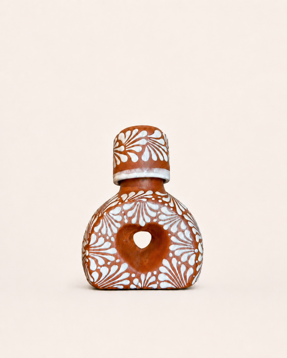 Ceramic liquor bottle with decorative patterns on a beige background