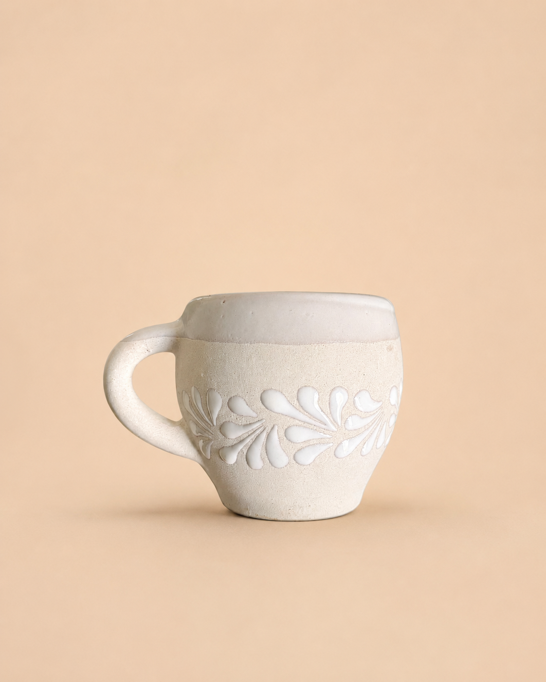 Ceramic mug with floral design on a beige background