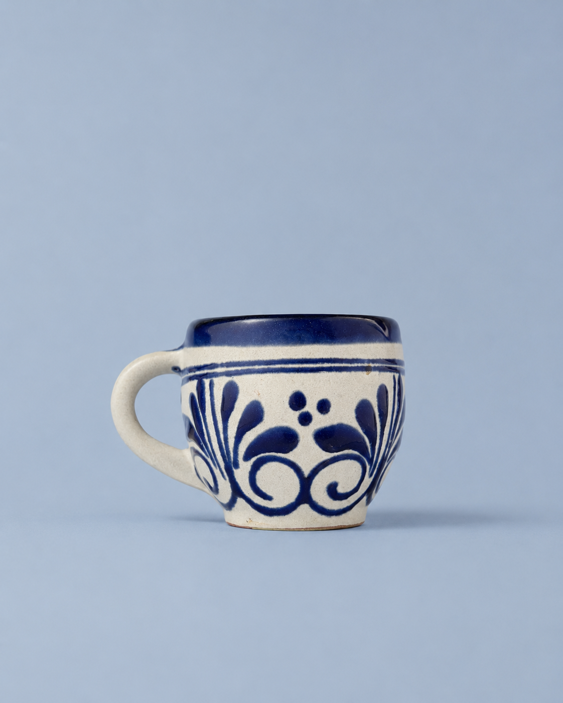 Ceramic mug with blue floral patterns on a light blue background