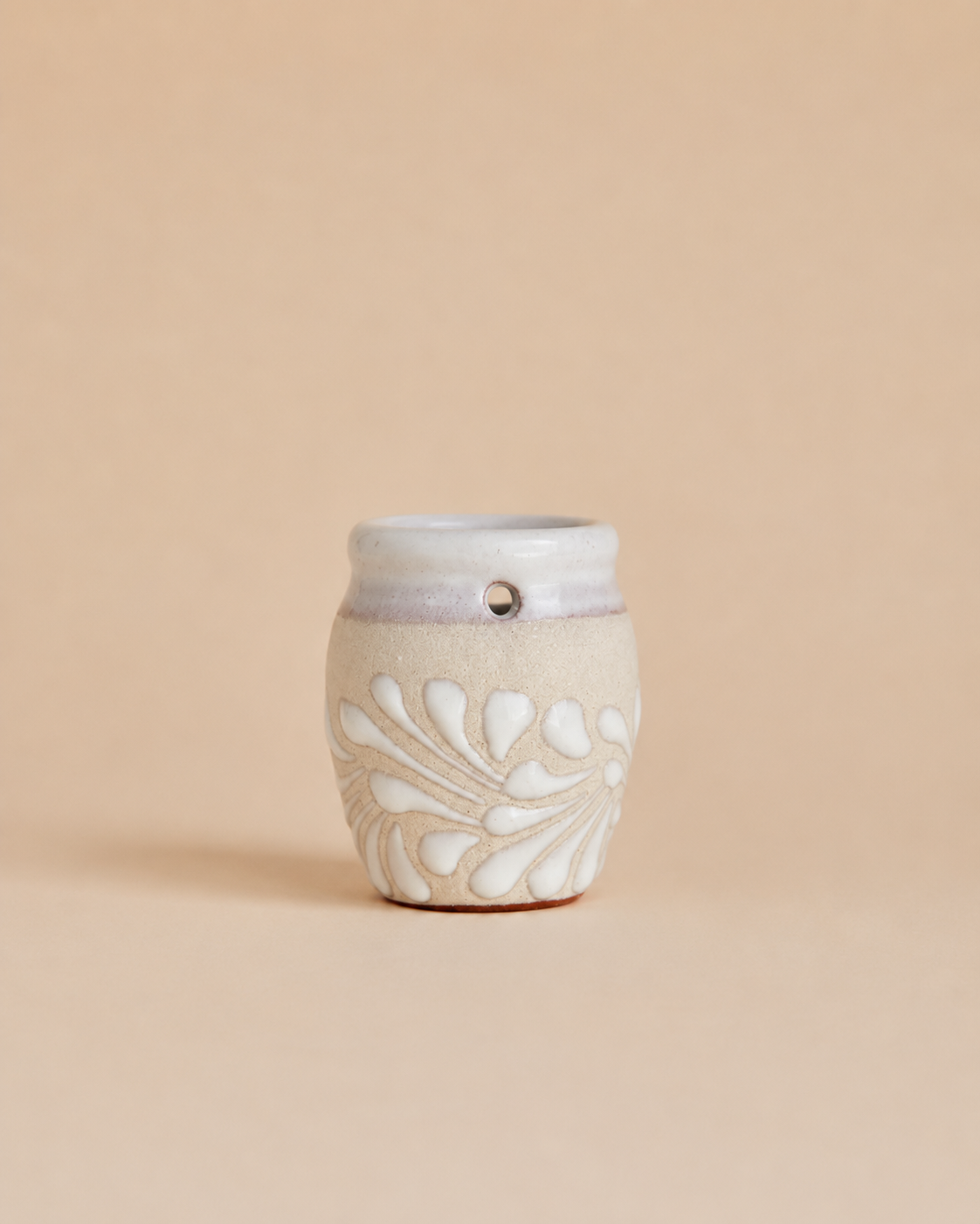 Shot glass with decorative design on a beige background