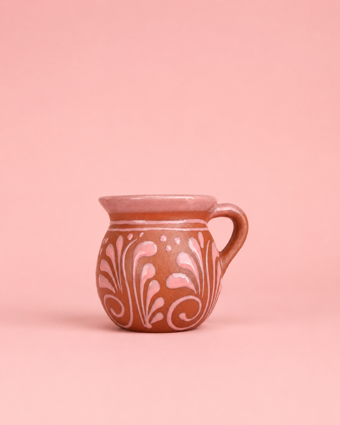 Ceramic mug with floral patterns on a pink background