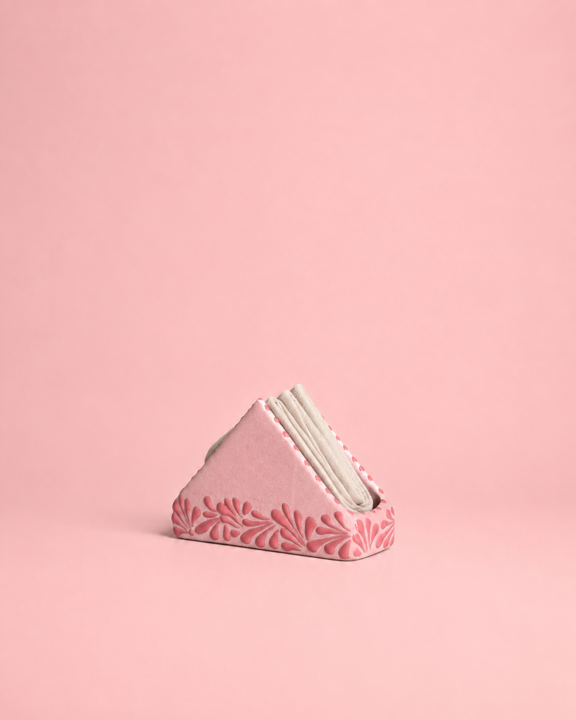Pink napkin holder with floral pattern on a pink background