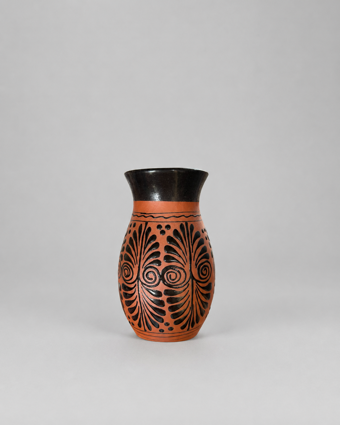 Ceramic vase with black decorative patterns on a gray background