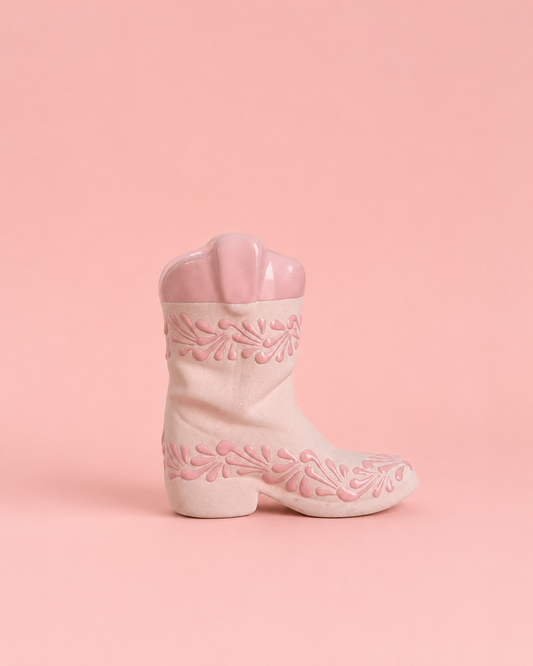 Pink cowboy boot with floral embroidery on a pink background