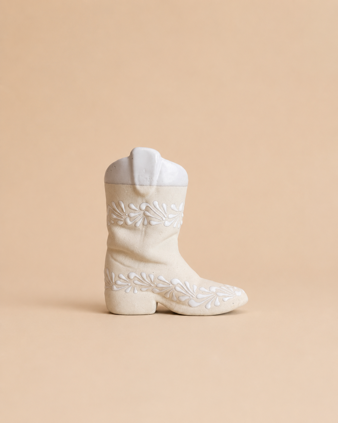 White embroidered boot on a beige background