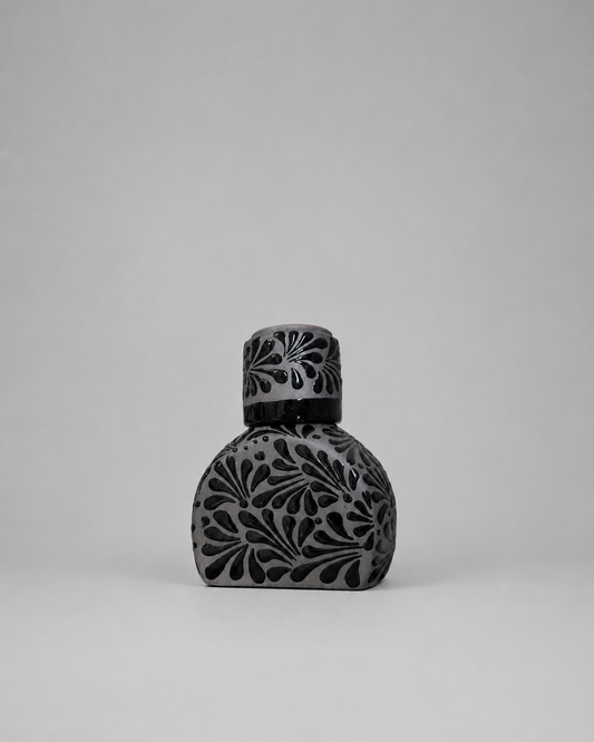 Decorative bottle with intricate patterns on a gray background