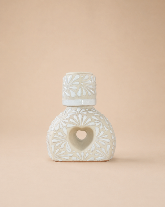 Ceramic liquor bottle with heart-shaped design on a beige background