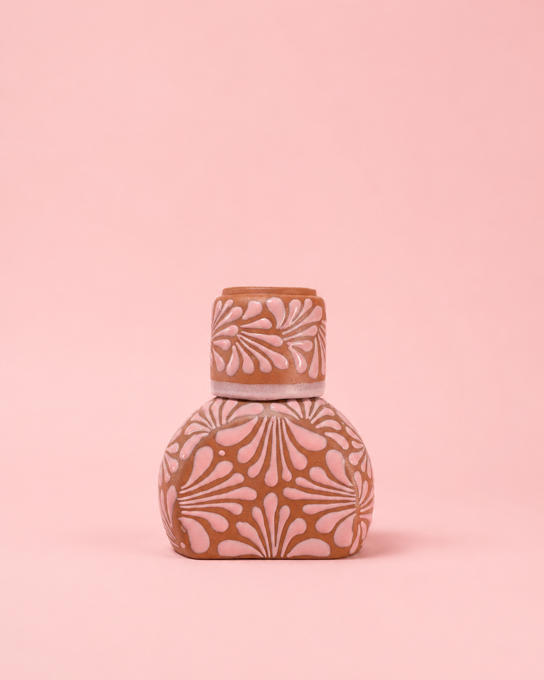 Decorative bottle with floral patterns on a pink background