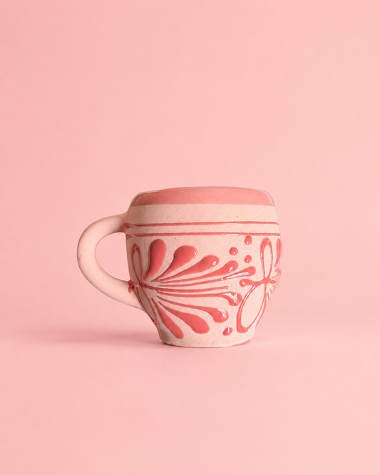 Ceramic mug with floral pattern on a pink background