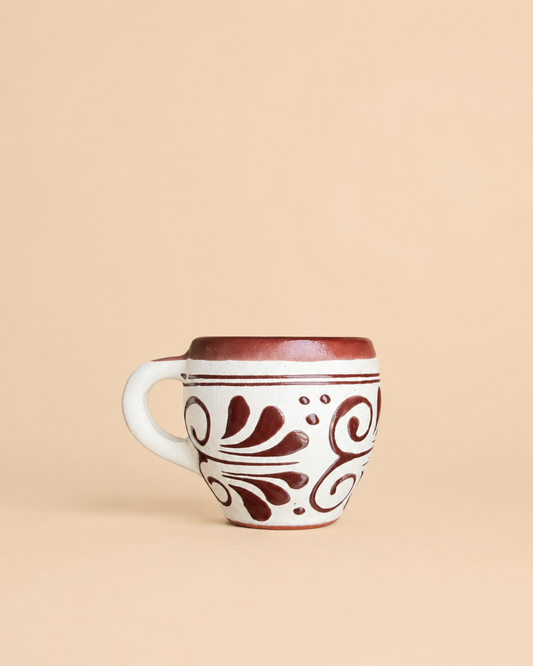 Ceramic mug with brown floral patterns on a beige background