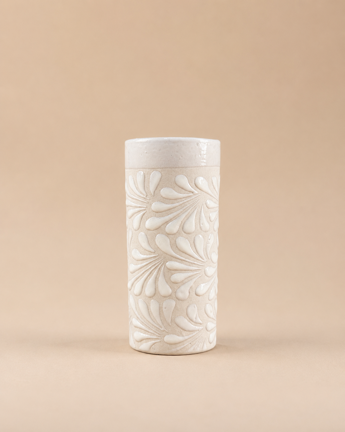 White ceramic cup with floral patterns on a beige background