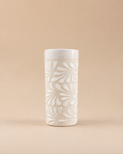 White ceramic cup with floral patterns on a beige background
