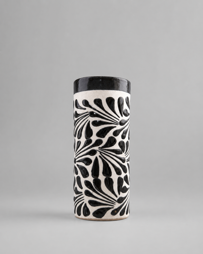 Cylindrical ceramic cup with black and white pattern on a gray background