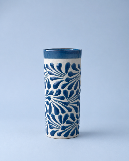 Ceramic tumbler with blue floral patterns on a light blue background