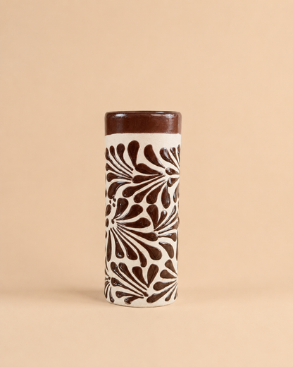 Tall cylindrical cup with brown floral pattern on a beige background