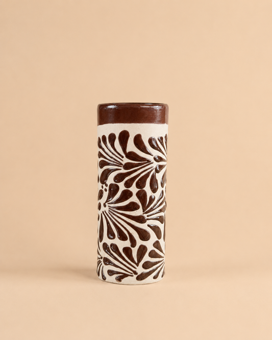 Tall cylindrical cup with brown floral pattern on a beige background