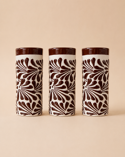 Three ceramic tumblers with brown and white pattern on a beige background