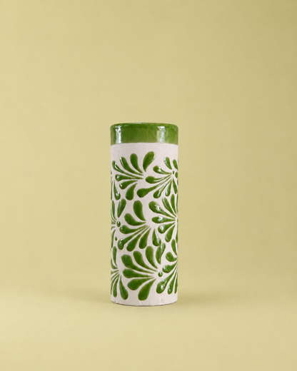 Tall cylindrical ceramic cup with green floral patterns on a light green background