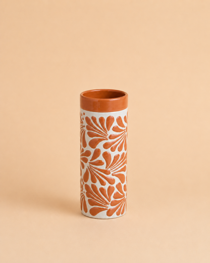 Tall cylindrical cup with floral pattern on a beige background
