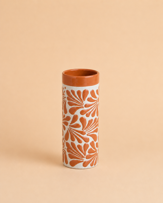 Tall cylindrical cup with floral pattern on a beige background