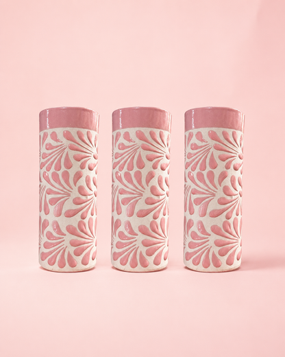 Three cylindrical tumblers with pink and white pattern on a pink background