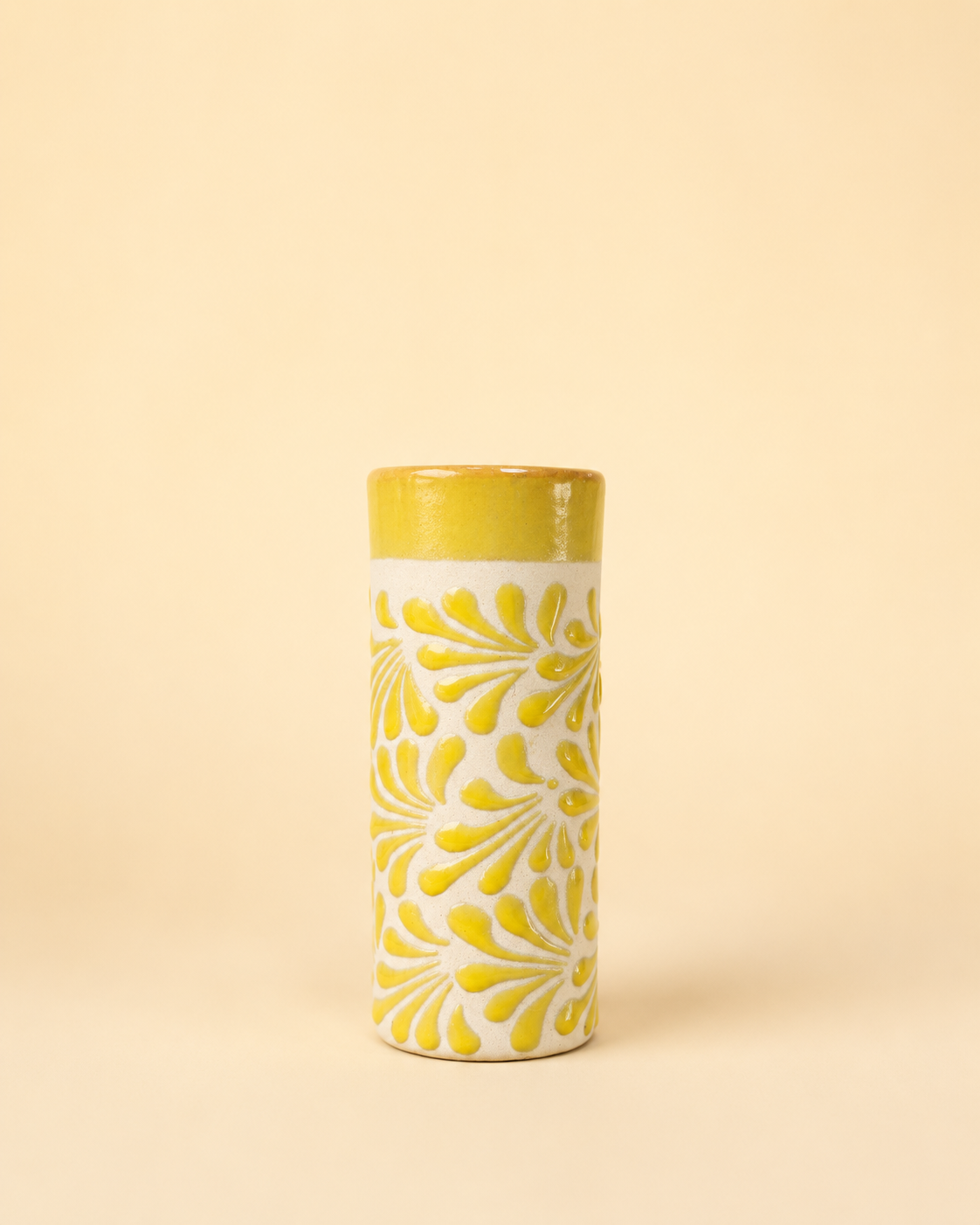 Tall cylindrical cup with yellow floral pattern on a beige background