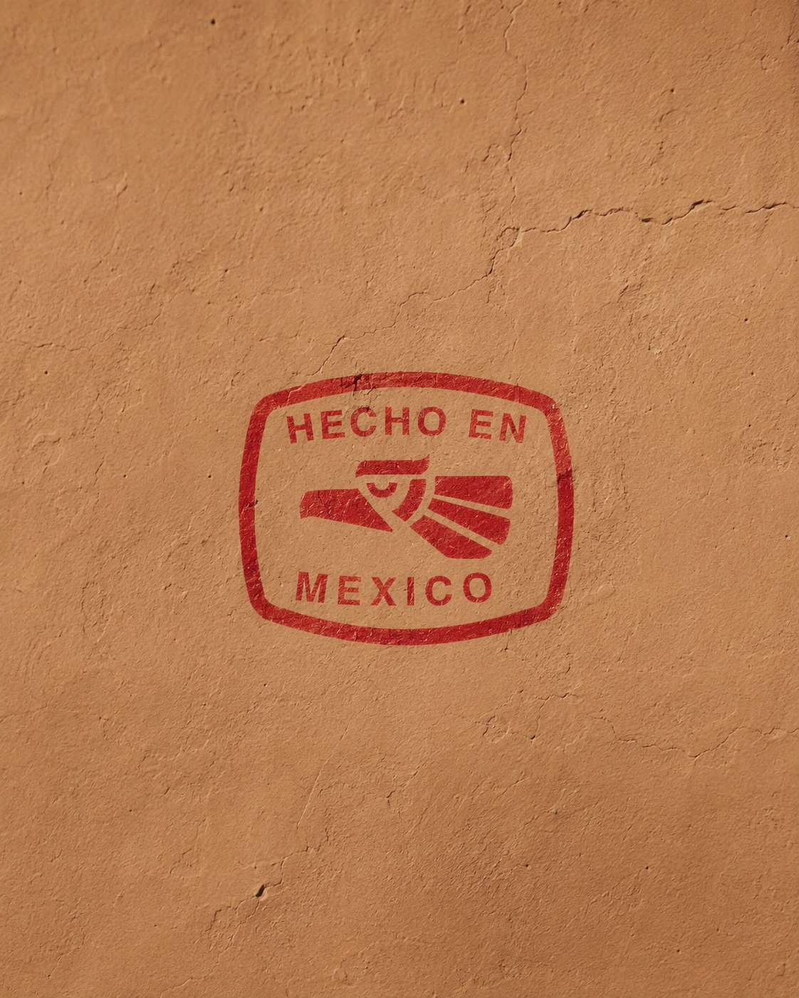 Logo "Hecho en Mexico" in red, on a orange clay wall