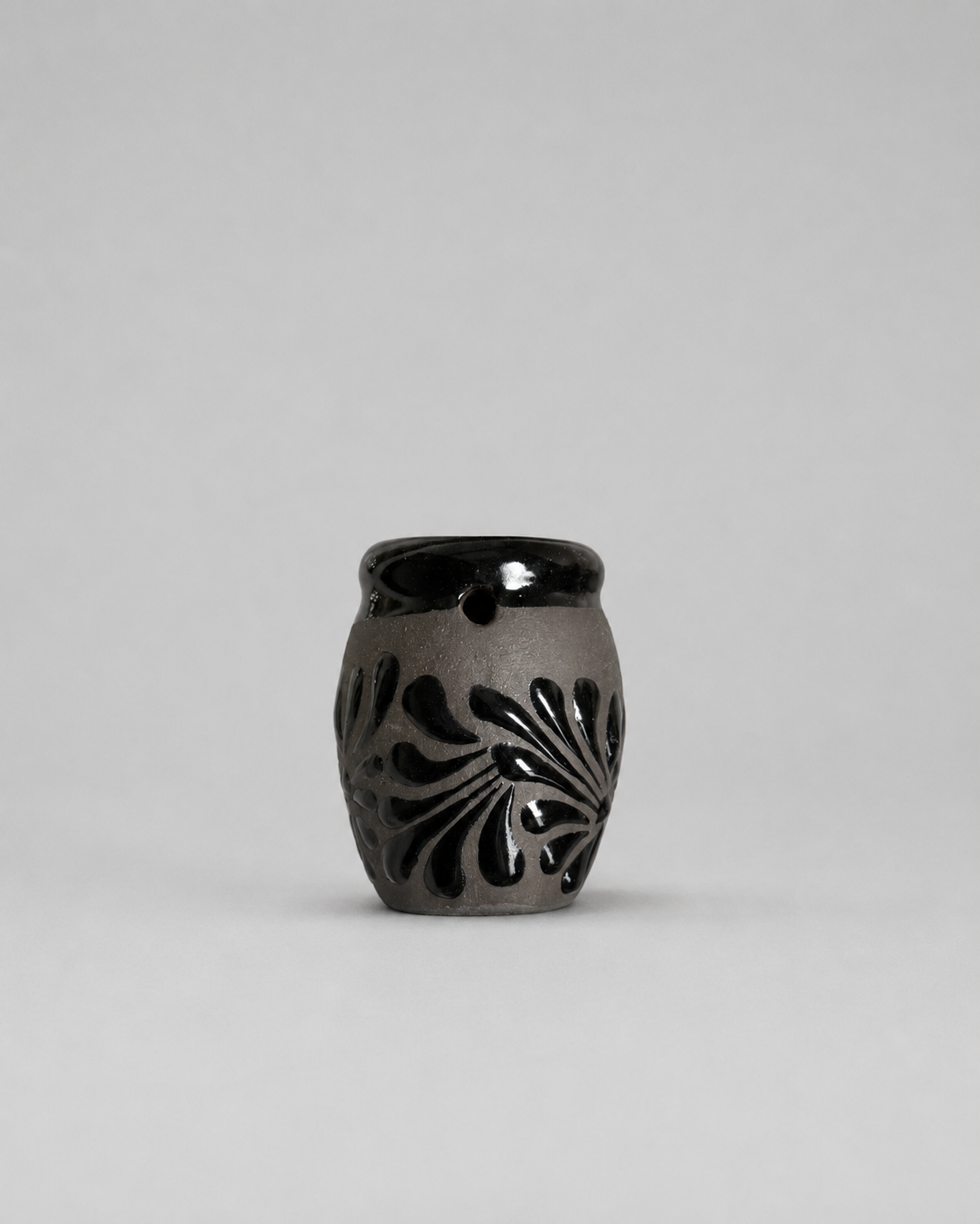 Shot glass with floral patterns on a gray background