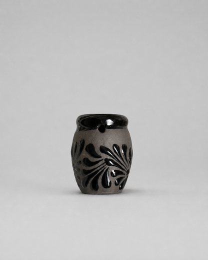 Shot glass with floral patterns on a gray background