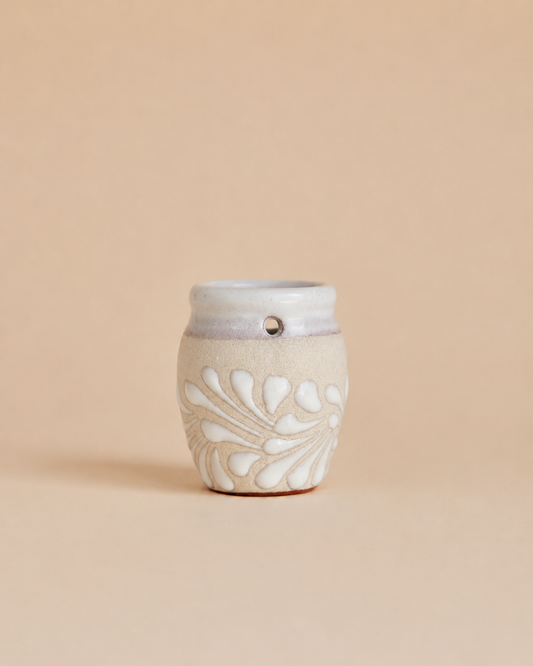 Shot glass with decorative design on a beige background