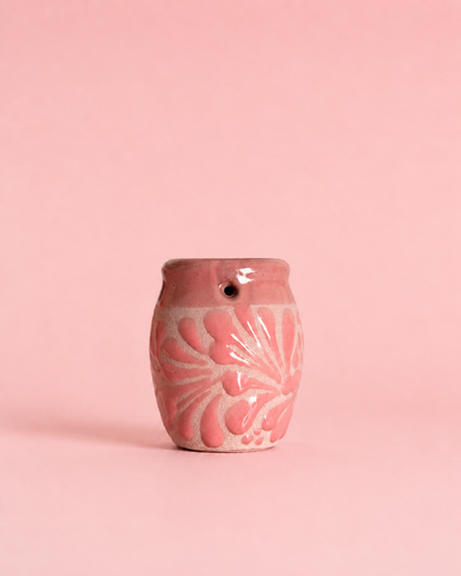 Shot glass with floral patterns on a pink background