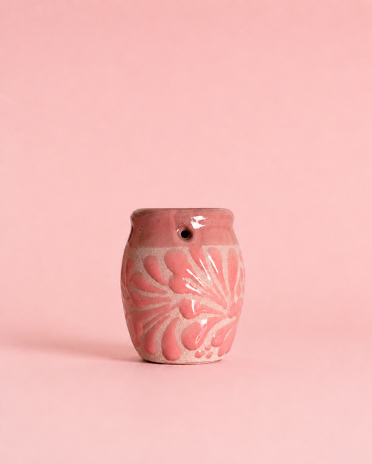 Shot glass with floral patterns on a pink background