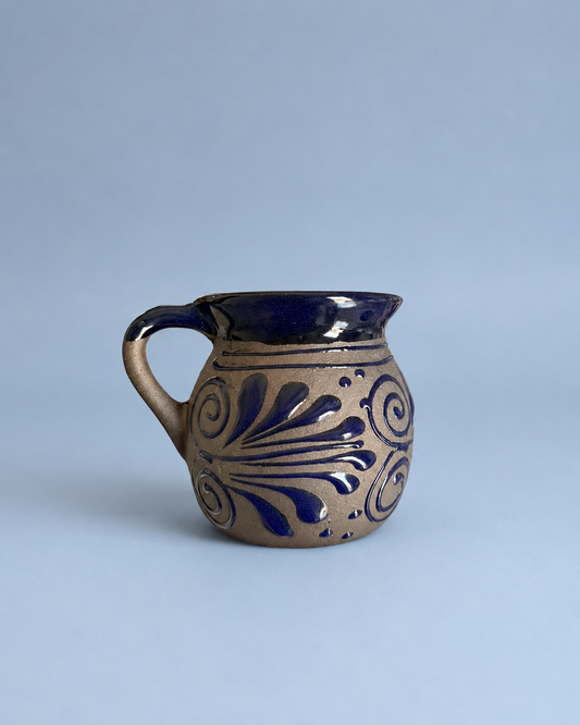 Ceramic mug with blue patterns on a light gray background