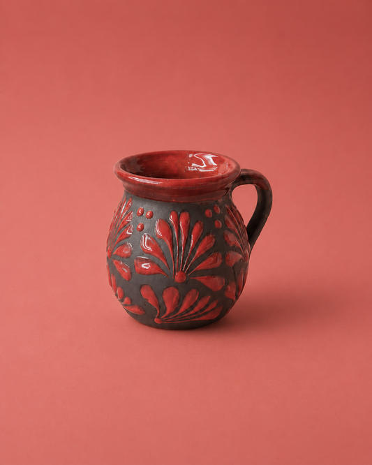 Ceramic mug with red floral patterns on a red background