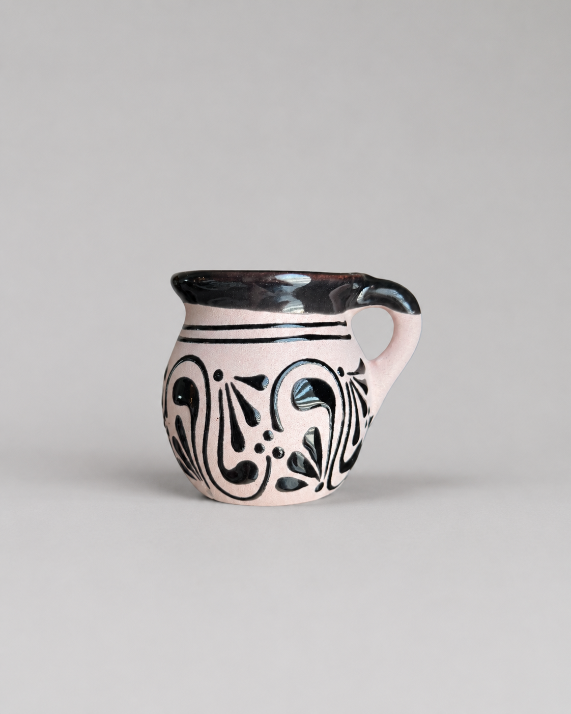 Ceramic mug with black patterns on a gray background