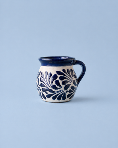 Ceramic mug with blue floral patterns on a light blue background