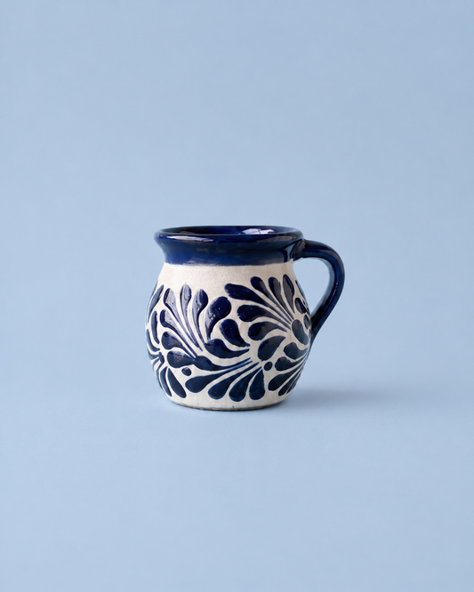 Ceramic mug with blue floral patterns on a light blue background