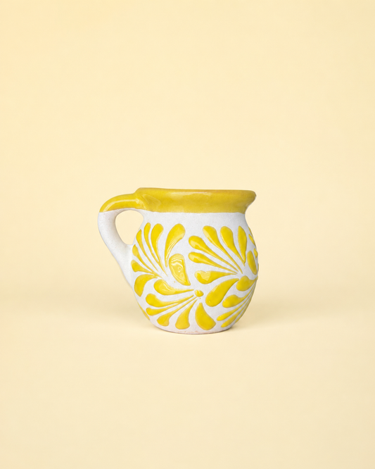Ceramic mug with yellow floral pattern on a beige background