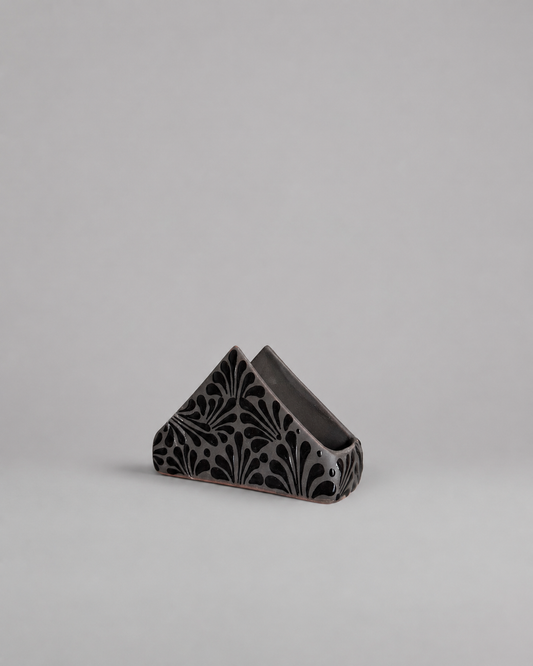 Black napkin holder  with black pattern on a light grey background