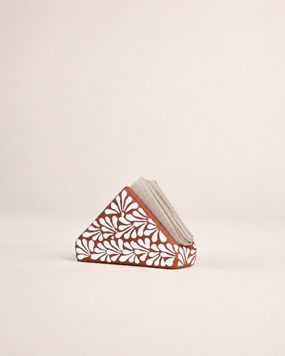 Triangular ceramic napkin holder  with floral patterns on a beige background