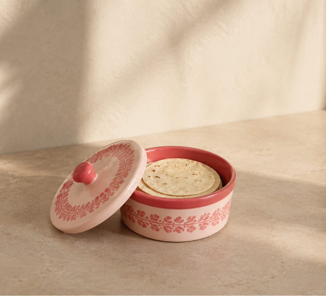 Pink ceramic container with tortillas on a ceramic surface