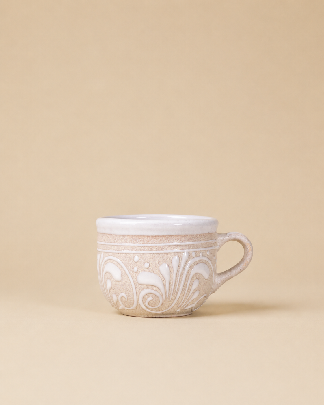 Ceramic mug with decorative patterns on a beige background