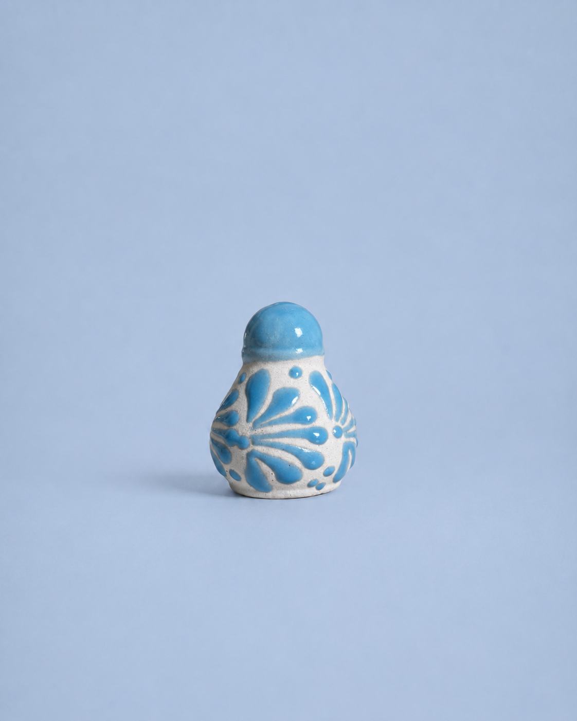 Ceramic salt shaker  with blue floral patterns on a light blue background