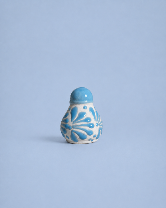 Ceramic salt shaker  with blue floral patterns on a light blue background
