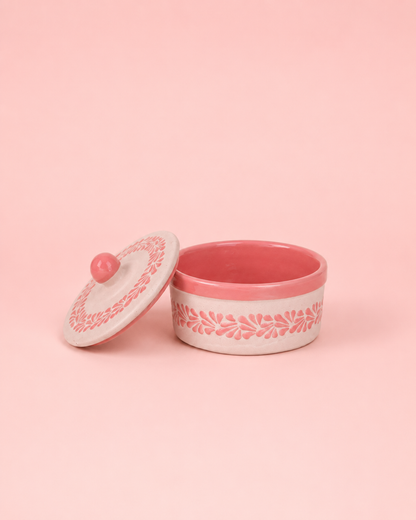 Pink ceramic container with lid on a pink background