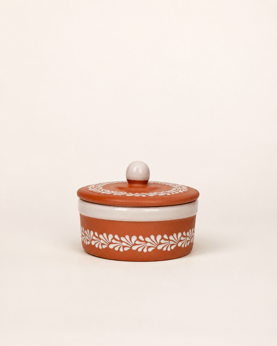 Ceramic tortilla container with white lid and floral patterns on a beige background
