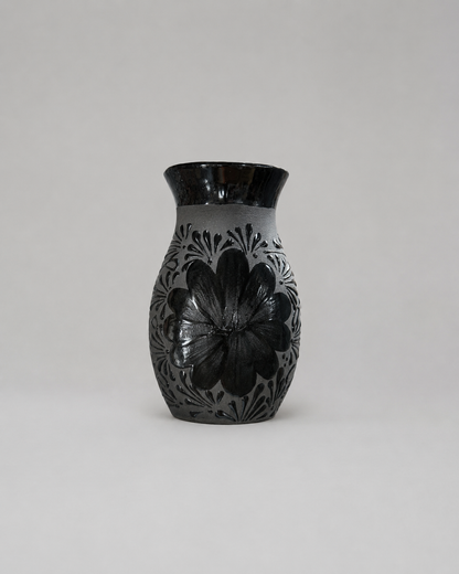 Black ceramic vase with floral patterns on a white background