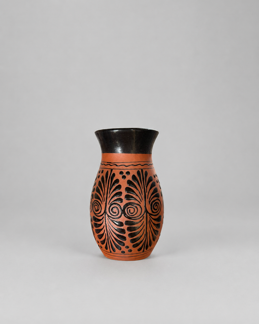 Ceramic vase with black decorative patterns on a gray background
